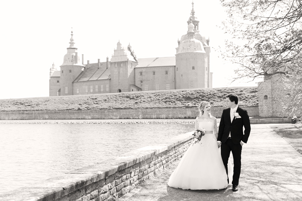 Brudpar som går framför Kalmar slott - bröllopsfotograf Phia Bergdahl Västervik