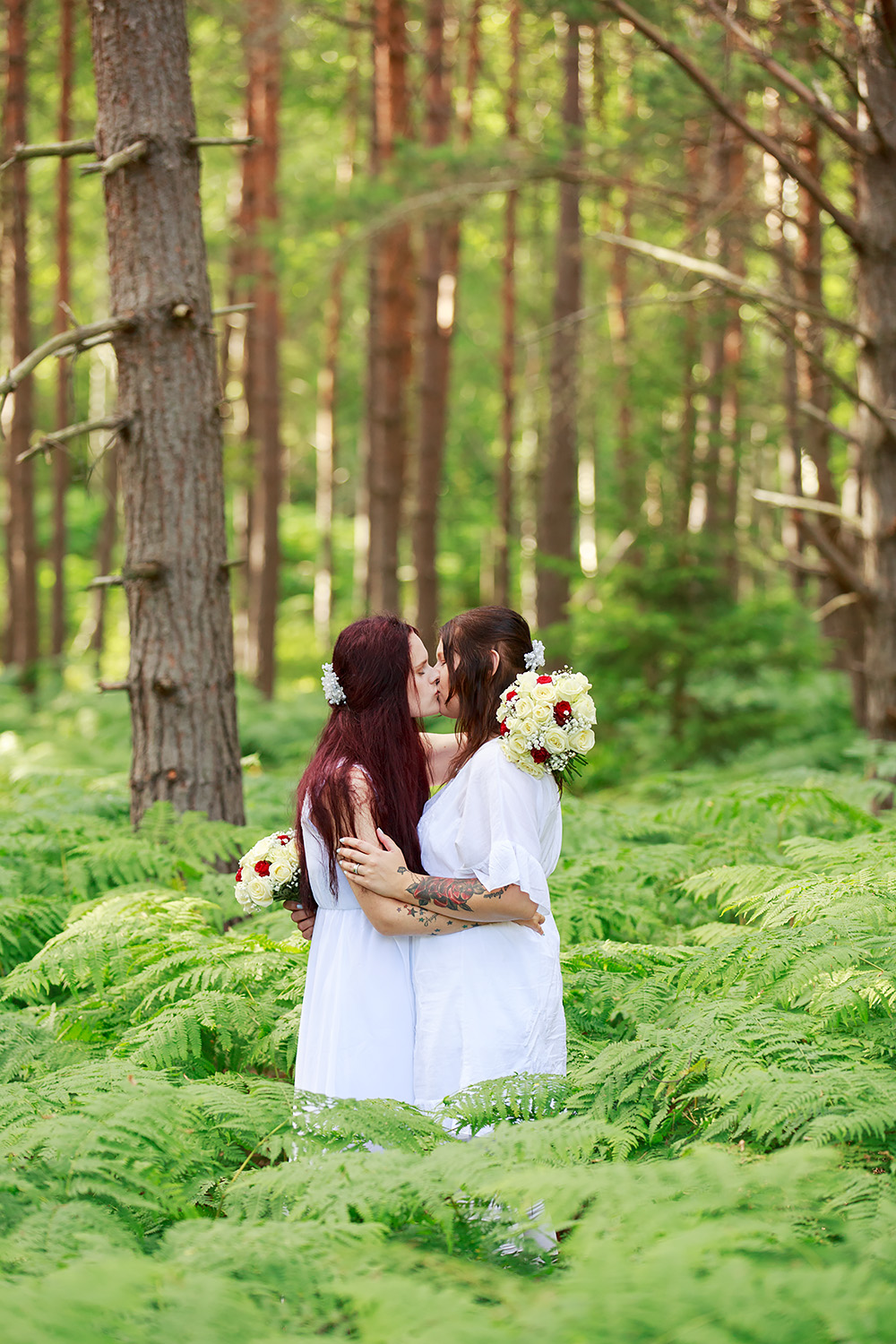 Brudar som kysser varandra i skogen på Gränsö