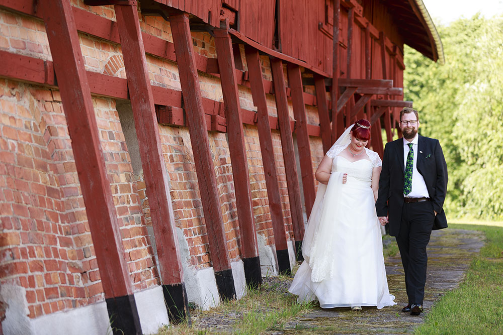 Brudpar som går vid Almviks tegelbruk - fotograferat av bröllopsfotograf Phia Bergdahl Västervik